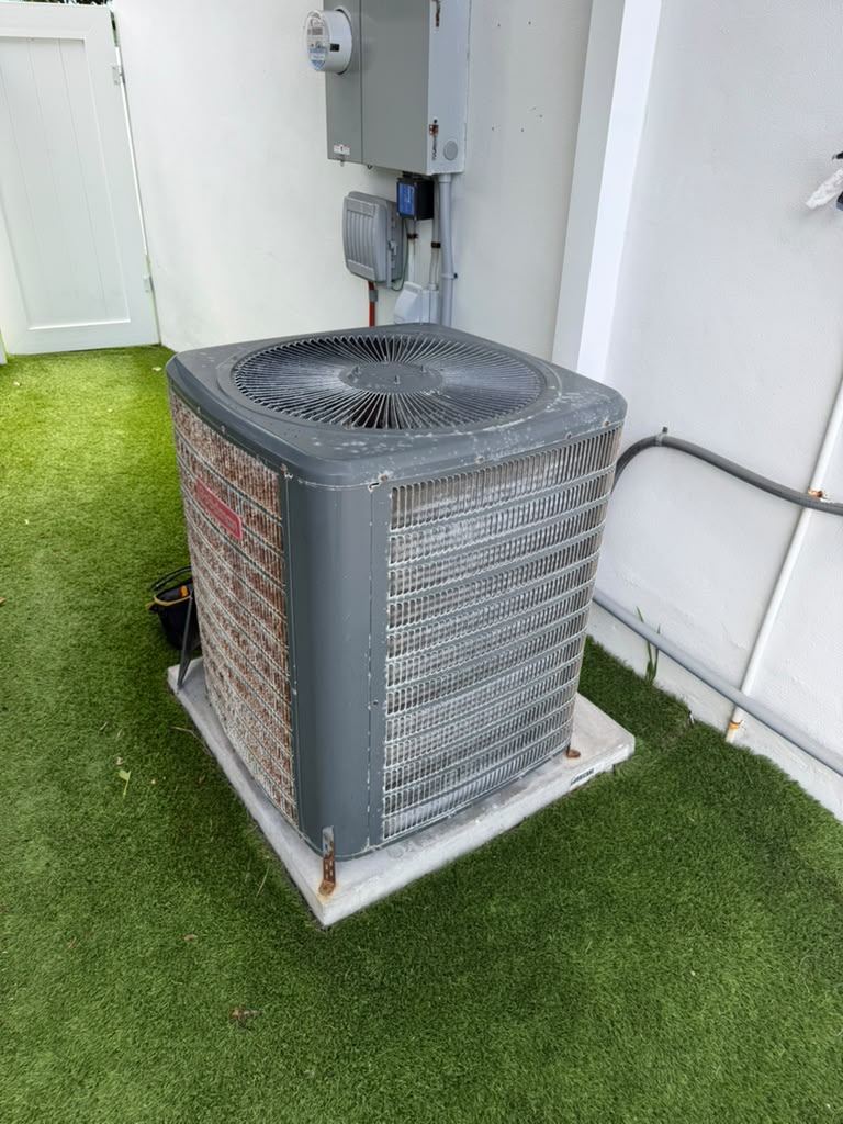 Outdoor condenser on a pad beside the house