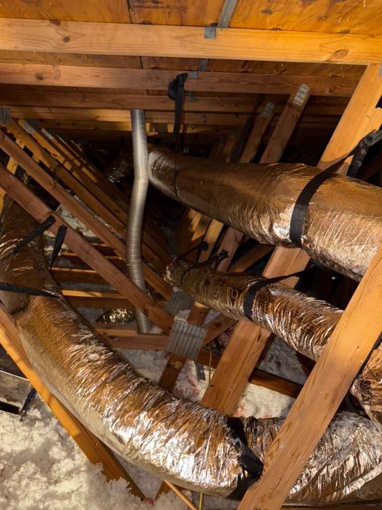 Replaced attic ductwork strapped along the ceiling joists